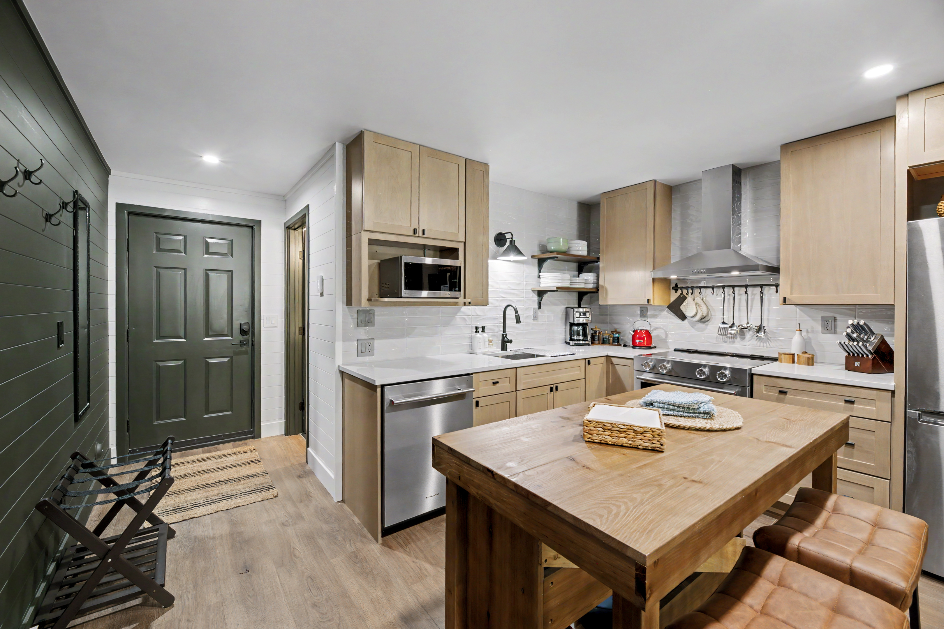 Kitchen entry with front door and shiplap walls