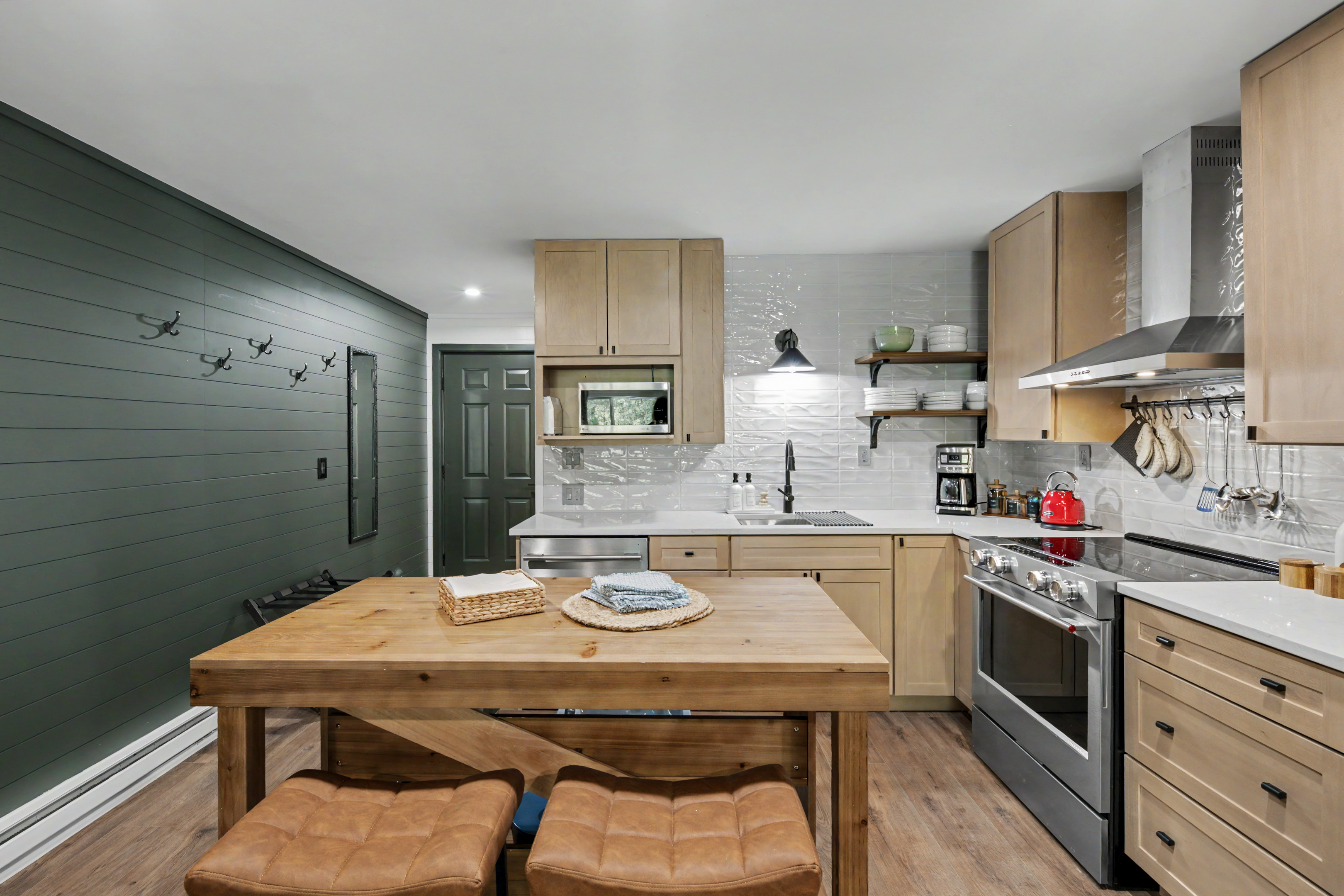 Kitchen with green shiplap wall and coat hooks