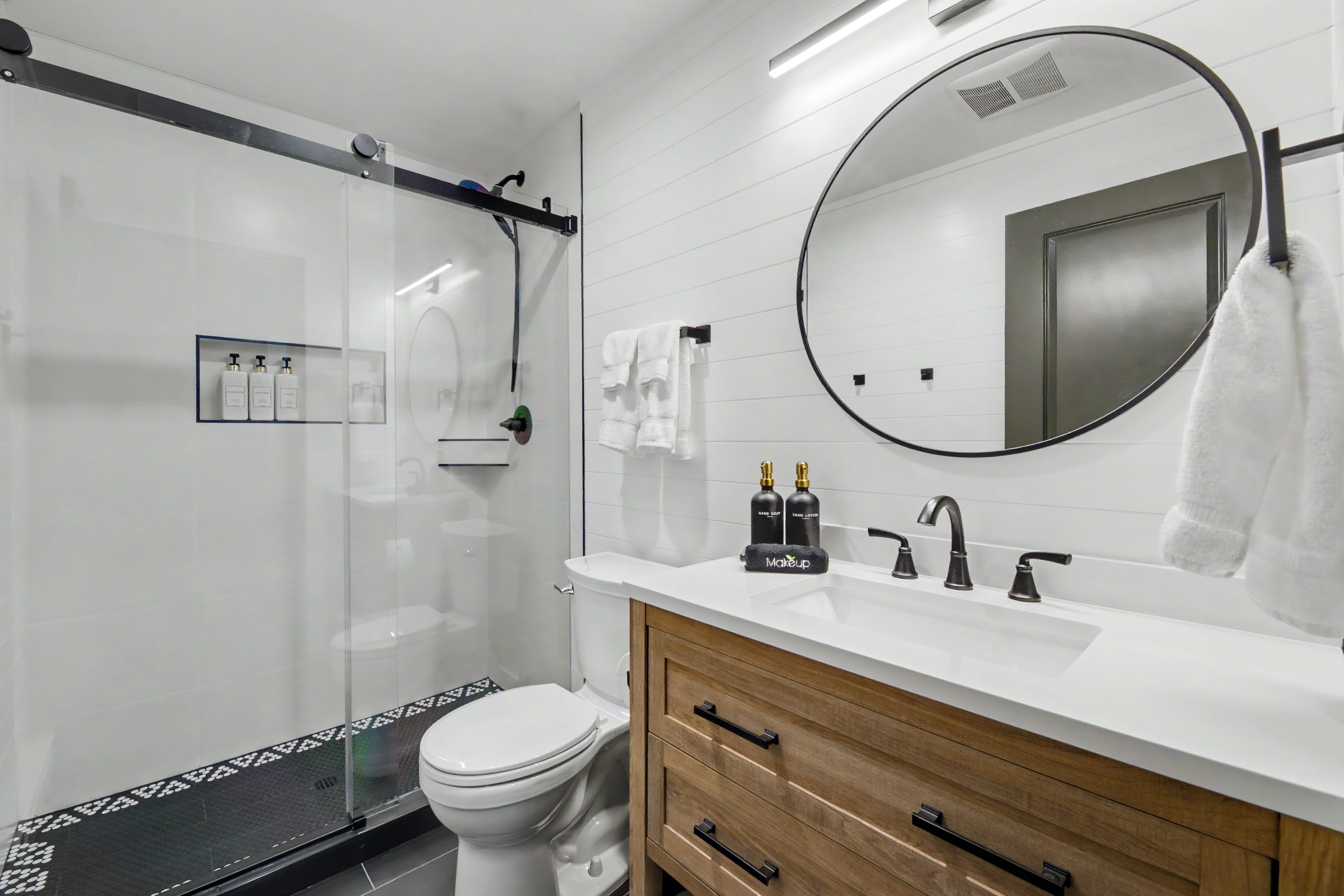 Bathroom with glass shower and round mirror
